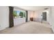 Bright living room featuring a large window with views, neutral carpet and a wrought iron railing at 3065 Zion St, Aurora, CO 80011