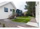 Spacious backyard with a well-kept lawn, stone pathway, and stairs to a deck, perfect for outdoor activities at 1101 S Dahlia St, Denver, CO 80246