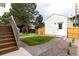 Landscaped backyard featuring a well-maintained lawn, wooden fence, and steps leading to the deck at 1101 S Dahlia St, Denver, CO 80246