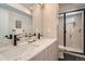 Bathroom with double sinks, speckled countertops, modern fixtures and a glass-enclosed shower at 1101 S Dahlia St, Denver, CO 80246