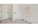 A simple bedroom with two doors, neutral carpet, and a window providing natural light at 1101 S Dahlia St, Denver, CO 80246