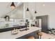 Open kitchen with island seating, pendant lighting, stainless steel appliances, and white subway tile backsplash at 1101 S Dahlia St, Denver, CO 80246