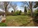 Spacious backyard with green lawn, mature trees, and privacy fencing perfect for outdoor enjoyment at 3821 S Magnolia Way, Denver, CO 80237