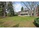 Expansive backyard view showing the home's rear facade and spacious lawn with mature trees at 3821 S Magnolia Way, Denver, CO 80237