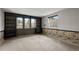 Finished basement showcasing built-in shelving, carpeted floors, and natural light from the windows at 3821 S Magnolia Way, Denver, CO 80237