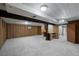 Finished basement with carpet flooring, exposed beams, bar area, and open layout at 3821 S Magnolia Way, Denver, CO 80237