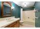 Bathroom with vanity sink, toilet, and bath with shower; decorated with blue wallpaper at 3821 S Magnolia Way, Denver, CO 80237