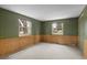 Bedroom with wood paneling, neutral carpet, and two windows providing ample natural light at 3821 S Magnolia Way, Denver, CO 80237