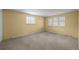 Spacious bedroom with three large windows, neutral walls, and carpet flooring at 3821 S Magnolia Way, Denver, CO 80237