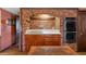 This kitchen features a brick archway, stainless steel appliances, wood cabinets and white countertops at 3821 S Magnolia Way, Denver, CO 80237