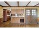Retro kitchen with wood cabinets, floral wallpaper, beamed ceiling, and breakfast bar, offering unique charm and functionality at 3821 S Magnolia Way, Denver, CO 80237