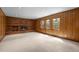 Spacious living room featuring wood paneling, a brick fireplace, and multiple windows for ample natural light at 3821 S Magnolia Way, Denver, CO 80237