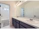 A well-lit bathroom featuring a double vanity, large mirror, and tub/shower combination at 18049 E 106Th Ave, Commerce City, CO 80022