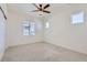 A bright bedroom with neutral carpet, light walls, and a modern ceiling fan at 18049 E 106Th Ave, Commerce City, CO 80022