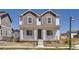 Charming two-story home featuring a welcoming front porch with classic columns and a well-maintained lawn at 18049 E 106Th Ave, Commerce City, CO 80022
