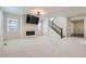 Spacious living room with a modern fireplace, large windows, and a staircase with black railing at 18049 E 106Th Ave, Commerce City, CO 80022