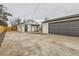 Wide view of backyard showcasing updated siding, a garage, green door and fresh landscaping at 1120 Xenia St, Denver, CO 80220