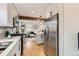 Bright open concept kitchen and living area showcases stainless steel appliances and plenty of cabinets at 1120 Xenia St, Denver, CO 80220