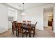 Formal dining room with dark wood table and view into hall with bathroom at 9374 Loggia St # D, Highlands Ranch, CO 80126