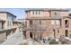 Front exterior view of a townhome featuring brick and stucco accents, an arched entryway, and low-maintenance landscaping at 9374 Loggia St # D, Highlands Ranch, CO 80126