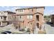 Charming townhome exterior featuring a mix of brick and stucco finishes with a small front yard at 9374 Loggia St # D, Highlands Ranch, CO 80126