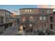Townhome with brick and stucco exterior, featuring an arched entrance and a well-lit pathway at 9374 Loggia St # D, Highlands Ranch, CO 80126