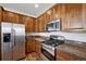 A well-equipped kitchen featuring stainless steel appliances and dark wood cabinets with granite countertops at 9374 Loggia St # D, Highlands Ranch, CO 80126