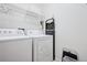 Bright laundry room with shelving and white washer and dryer units at 9374 Loggia St # D, Highlands Ranch, CO 80126