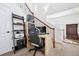 A multi-level landing features an office with desk and shelving near a wood and wrought iron staircase at 9374 Loggia St # D, Highlands Ranch, CO 80126