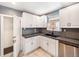 Well-lit kitchen featuring white cabinets, modern appliances, and a beautiful tile backsplash at 1470 Utica St, Denver, CO 80204