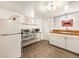Basement kitchen with stainless steel appliances, butcher block countertops, white cabinets and a refrigerator at 1470 Utica St, Denver, CO 80204