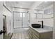 Bathroom featuring shower, tiled floor, vanity with modern fixtures and artwork at 375 Castlewood Dr, Evergreen, CO 80439