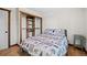 Comfortable bedroom featuring closet, wood trim, and forest themed bedspread at 375 Castlewood Dr, Evergreen, CO 80439