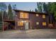 Two-story home with a deck and a charming front entrance surrounded by lush greenery at 375 Castlewood Dr, Evergreen, CO 80439