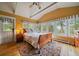 Sunlit bedroom featuring a vaulted ceiling, wood floors, and large windows with views of mature trees at 3800 Lakota Rd, Indian Hills, CO 80454