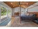 Spacious bedroom with a wood framed bed, wood paneled ceiling, sliding glass doors and multiple windows at 3800 Lakota Rd, Indian Hills, CO 80454