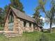 Unique stone building with a gable roof, complemented by natural stone steps and lush greenery in a tranquil setting at 3800 Lakota Rd, Indian Hills, CO 80454