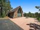 Charming stone building with a large patio and architectural details, perfect for outdoor entertaining and scenic views at 3800 Lakota Rd, Indian Hills, CO 80454
