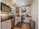 Modern kitchen features stainless steel appliances, bright white cabinets and a large farmhouse sink at 3800 Lakota Rd, Indian Hills, CO 80454