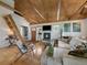 Bright living room with vaulted ceiling, exposed beams, cozy fireplace and wood floors at 3800 Lakota Rd, Indian Hills, CO 80454