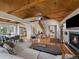 Inviting living room boasts wood-beamed ceilings, a fireplace, and an open floor plan with plenty of light at 3800 Lakota Rd, Indian Hills, CO 80454