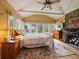 Serene main bedroom featuring a stone fireplace, vaulted ceilings, and large windows with scenic views at 3800 Lakota Rd, Indian Hills, CO 80454