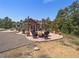 Outdoor patio featuring a stone fireplace, comfortable seating, artistic decor, and a scenic backdrop at 3800 Lakota Rd, Indian Hills, CO 80454