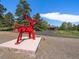 Eye-catching red bull sculpture on a concrete slab with a garage in the background adding a touch of contemporary art at 3800 Lakota Rd, Indian Hills, CO 80454