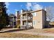 Tan two-story building with balconies, landscaping, and a walkway at 1960 S Xanadu Way # 208, Aurora, CO 80014