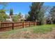 Large backyard featuring a wooden fence and mature trees in a beautiful setting at 4570 S Kalispell Way, Aurora, CO 80015