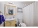Bright bathroom with vanity, toilet, a shower with a decorative shower curtain, and a mirror at 4570 S Kalispell Way, Aurora, CO 80015