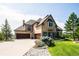 Elegant home showcasing manicured landscaping, a stone facade, and three-car garage at 4320 Stone Post Dr, Castle Rock, CO 80108