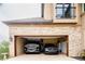 Spacious three-car garage featuring vehicles, stone facade, and built in shelving at 4320 Stone Post Dr, Castle Rock, CO 80108