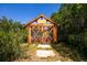 Charming wooden greenhouse with 'Made With Love' sign nestled in a lush garden setting at 4320 Stone Post Dr, Castle Rock, CO 80108